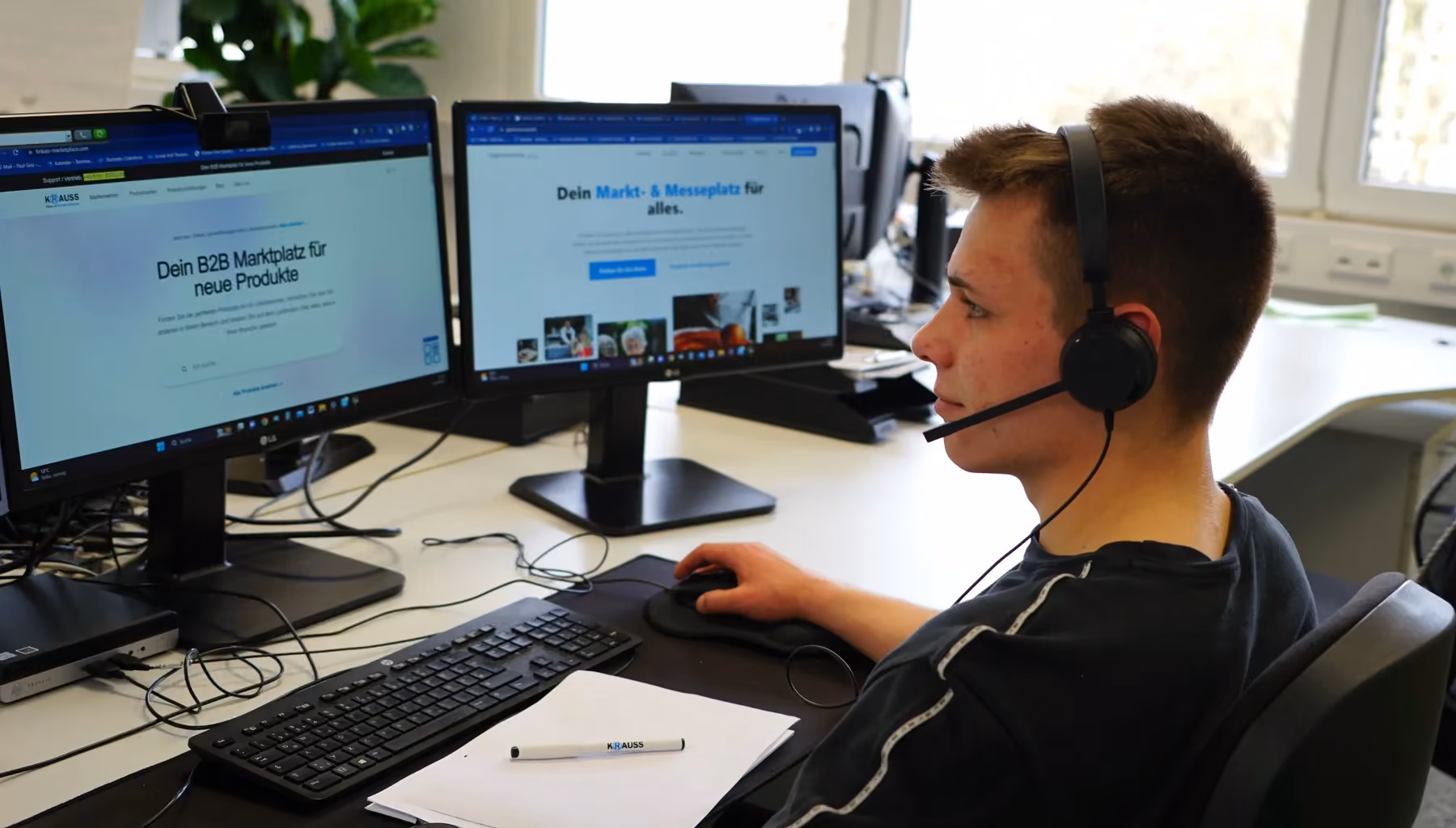 Ein KRAUSS-Mitarbeiter telefoniert mit Headset am Arbeitsplatz.